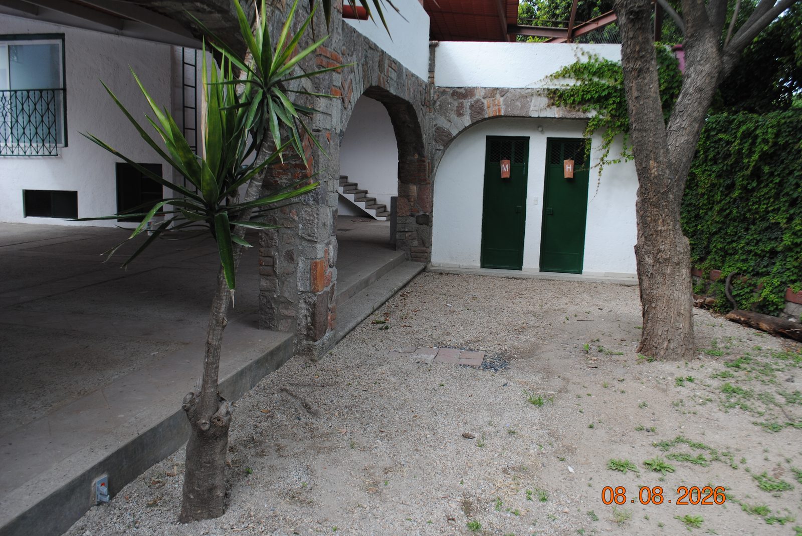 Entrada a los baños de mujeres y hombres bajo arco de piedra
